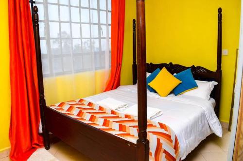 MeruEP Home的一间卧室配有带橙色和蓝色枕头的床