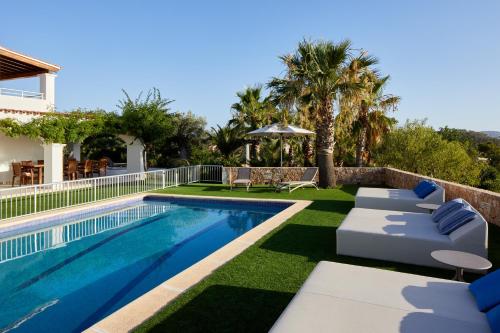 圣安东尼奥Villa Can Joan I - Fantastic Sunset Views and Family Friendly -的一个带躺椅的游泳池以及一座房子