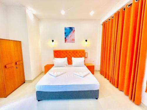 阿努拉德普勒ismattha hotel的一间卧室配有橙色窗帘的床