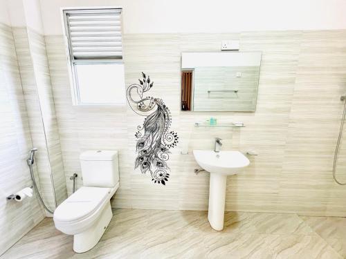 阿努拉德普勒ismattha hotel的浴室配有卫生间、水槽和镜子