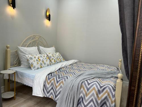 阿克套Квартира в Актау 362的小卧室配有带床罩和枕头的床