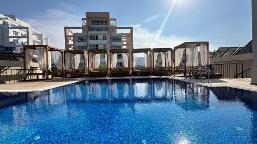 凯里尼亚Olivia Palm Hotel的一座大型蓝色游泳池,位于一座建筑的顶部