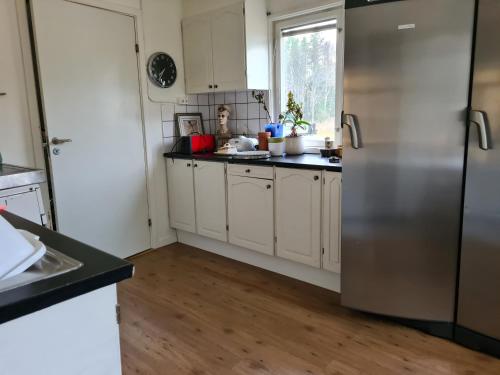 Mattmar vila的厨房配有白色橱柜和不锈钢冰箱