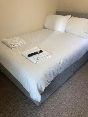 新港Town House 8-8A High Street的一张带白色床单的床和一本书