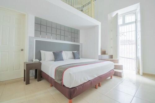 萨卡特卡斯Mansión Aréchiga的一间白色客房内配有一张大床的卧室