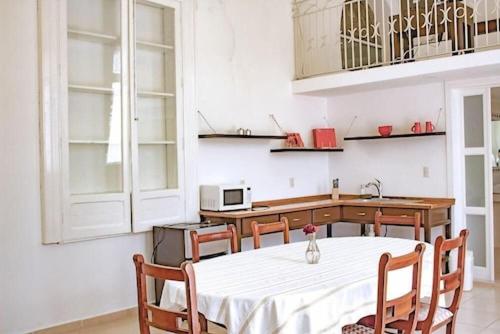 萨卡特卡斯Mansión Aréchiga的厨房配有白色的桌椅和柜台。