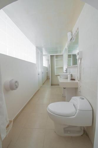 萨卡特卡斯Mansión Aréchiga的白色的浴室设有卫生间和2个盥洗盆。
