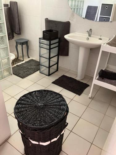 勒唐蓬Kaz Zézère ô coeur du Bras Creux Tampon的一间带水槽、卫生间和篮子的浴室