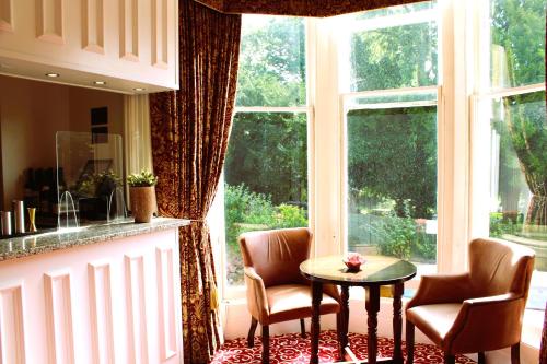 布里斯托克利夫顿村维多利亚广场酒店的厨房配有两把椅子和一张桌子,位于窗户前