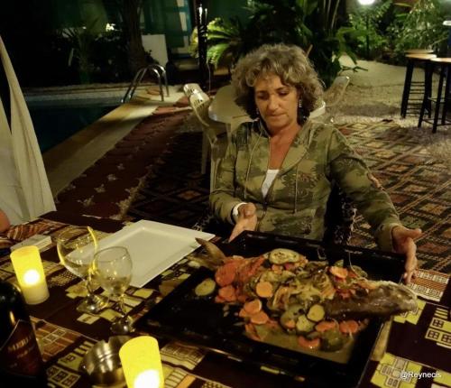 斯基灵角SAFARI Lodge Location Bungalow的坐在桌子上拿着食物盘的女人