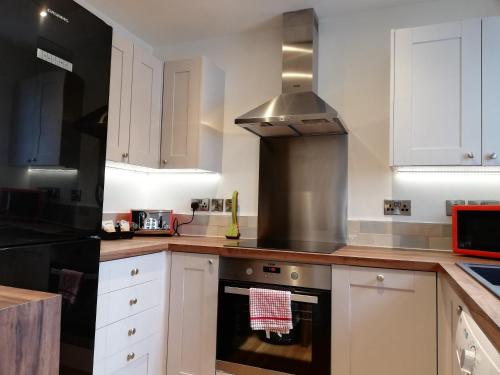 纽伯里Kings Road a new development with unique features的厨房配有白色橱柜和炉灶烤箱。