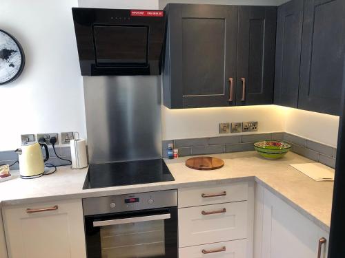 纽伯里Crown House is a brand new development with unique features的厨房配有黑色橱柜和炉灶烤箱。