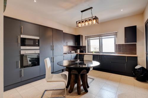 东勒贡10 bedroom Luxurious Villa的厨房配有黑色橱柜和桌椅