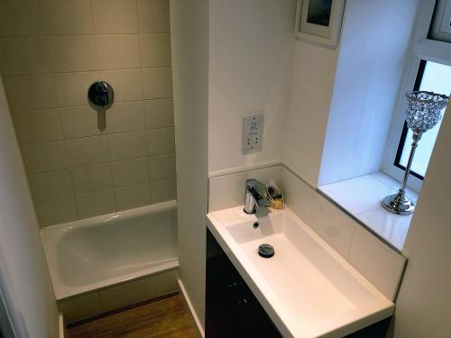 纽伯里Crown House is a brand new development with unique features的浴室配有盥洗盆和浴缸。