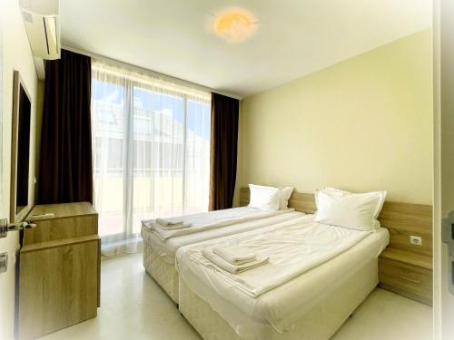 普里莫尔斯科Apartments Stamopolu Lux with pool view的一间卧室设有一张大床和一个大窗户