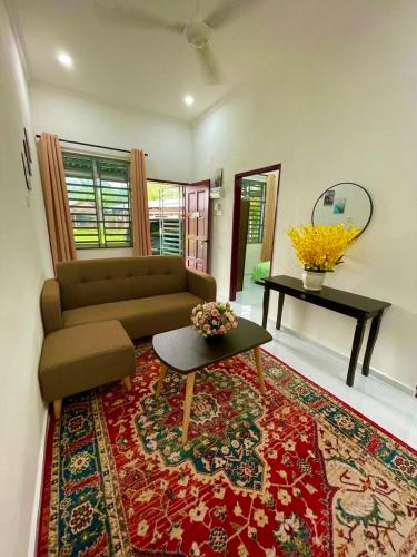 大山脚Tok Abah Homestay Bukit Mertajam的客厅配有沙发和一张桌子,铺在地毯上