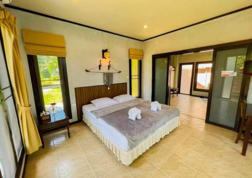 攀牙Waterjade Resort的一间卧室配有一张大床和毛巾