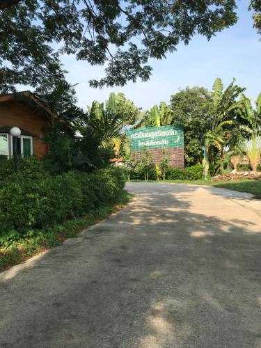 巴吞他尼Sripiamsuk Resort Bangkok的建筑前方有标志的道路