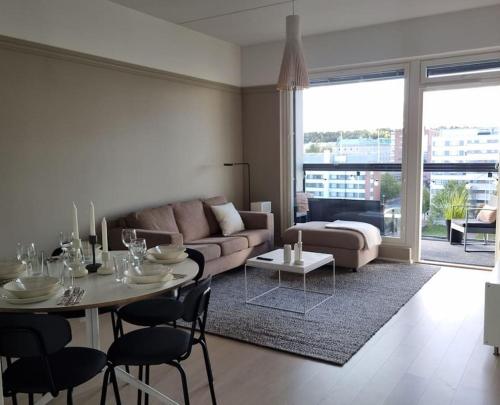 坦佩雷Hotellitasoinen, uusi huoneisto!的客厅配有沙发和桌椅