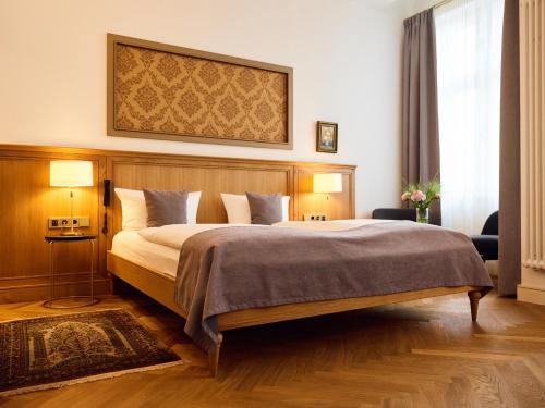 柏林林登乌法酒店的一间卧室配有一张大床和木制床头板