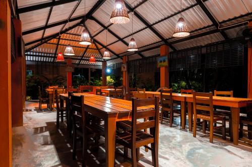 卡特勒格默Safari Lodge Yala的餐厅设有木桌和椅子及灯