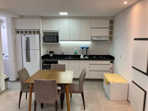 卡庞达卡诺阿Apartamento a 100m da beira-mar的厨房配有桌椅和冰箱。