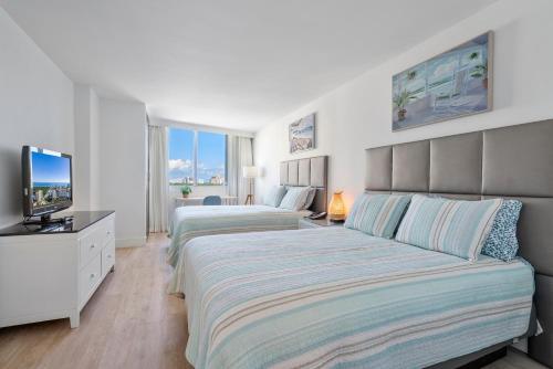 劳德代尔堡Beach Apartments by Avi Real Estate的一间卧室配有两张床和电视。