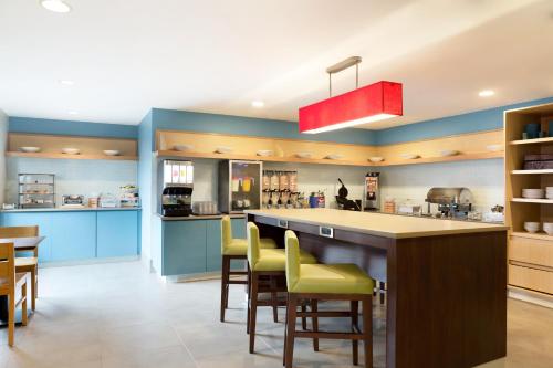 杰克逊卡尔森杰克逊江山旅馆 的厨房设有蓝色的墙壁和带黄色吧台凳的台面。