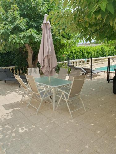 艾居厄河畔卡马勒Villa Gesinacris avec piscine的桌椅、遮阳伞和游泳池