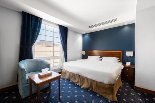 麦地那فندق ايديل هوم Ideal home hotel的酒店的客房 - 带一张床、椅子和窗户