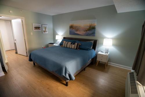 默特尔比奇Sunny Seaside Escape Perfect for Couples的一间卧室配有一张带蓝色棉被的床