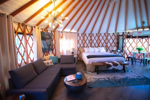 埃斯卡兰特Escalante Yurts - Luxury Lodging的蒙古包内带一张床和一张沙发的客厅