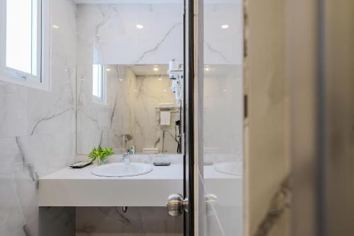 大叻TTR Moonstone Apart Hotel的白色的浴室设有两个盥洗盆和镜子
