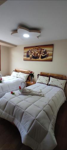 奥塔瓦洛Hospedaje La Joya的一间带两张带白色毯子的床的卧室