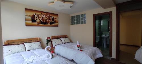 奥塔瓦洛Hospedaje La Joya的一间卧室配有两张带白色床单的床