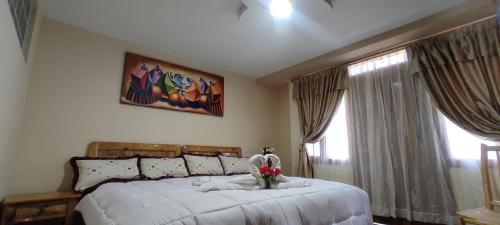 奥塔瓦洛Hospedaje La Joya的一间卧室配有一张白色大床,床上有鲜花
