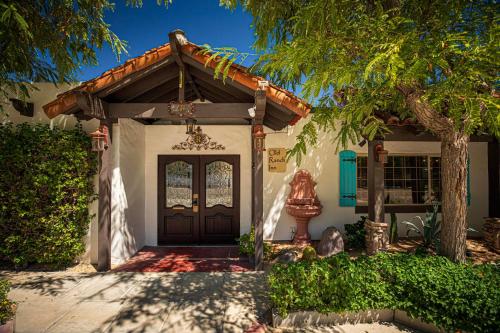 棕榈泉Old Ranch Inn - Adults Only 21 & Up的一座木门和一棵树的房子