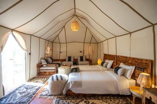 梅尔祖卡Golden Camp & Oasis的帐篷内一间卧室,配有四张床
