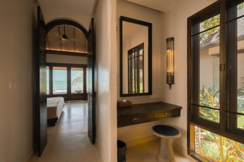 沙美岛Samed Tamarind Beach Resort的走廊上,有镜子和凳子