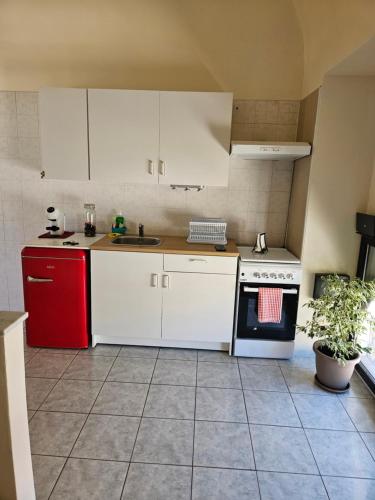 贝内文托Casa Gian的厨房配有白色橱柜和红色冰箱