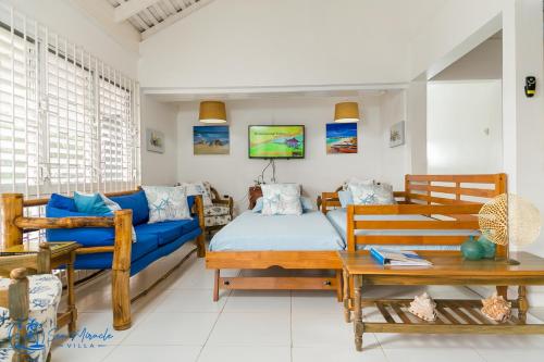 银沙Sea Miracle Villa/Beach Cottage的客厅配有蓝色的沙发和桌子