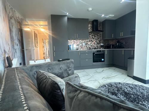 斯劳Two bed apartment with balcony Slough,Windsor,Legoland的带沙发的客厅和厨房
