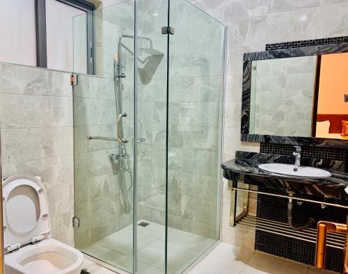 姆贝亚Royal Tughimbe Hotel的带淋浴、卫生间和盥洗盆的浴室