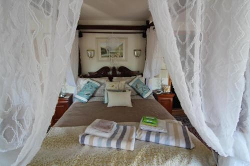 卡姆尔福德Melorne Farm Guest House的一间卧室配有一张床,上面有两条毛巾