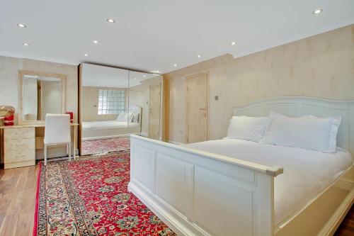 伦敦Noel Oasis : London Retreat的一间卧室配有一张床、一张书桌和一面镜子