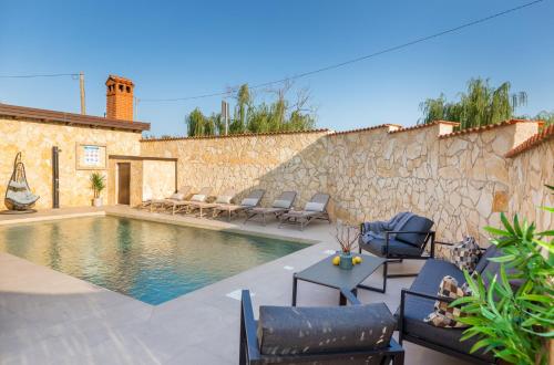 普拉Villa Miromar的一个带椅子和石墙的游泳池