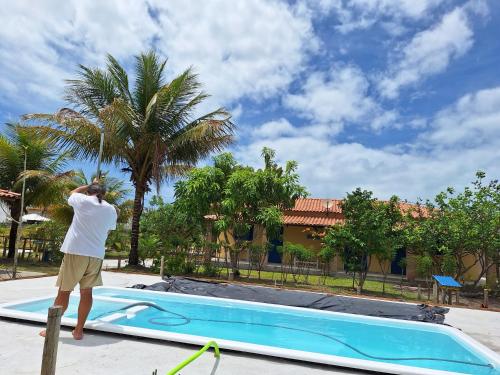 Costa DouradaCasas lindas no paraiso!的站在泳池旁的杆子上的人