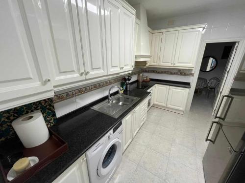 阿利坎特R-1-Комната в квартире для 2 человек -Alicante centro的厨房配有白色橱柜、水槽和洗碗机。