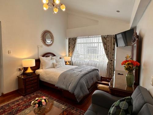 库斯科Hotel-Apartment INKASABIOS的一间卧室设有床、窗户和沙发