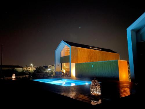 MurtosaModern barn house in countryside的一座晚上设有游泳池的建筑